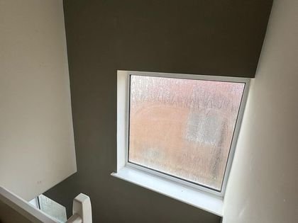 The finished stairway wall in deep olive with crisp white woodwork